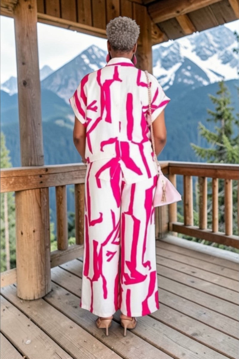 Person wearing a pink and white patterned outfit on a wooden deck with mountain view